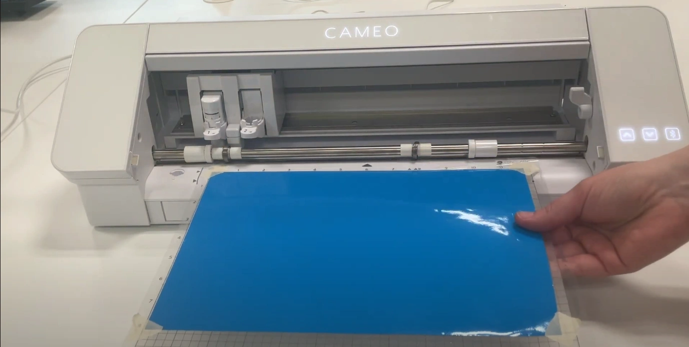 Hold the mat against the rollers and press the glowing up arrow